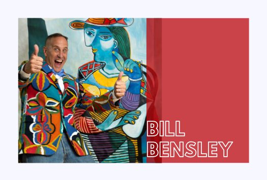 A Bill Bensley branded image with a men smiling with thumbs up in colourful suit in front of a painting