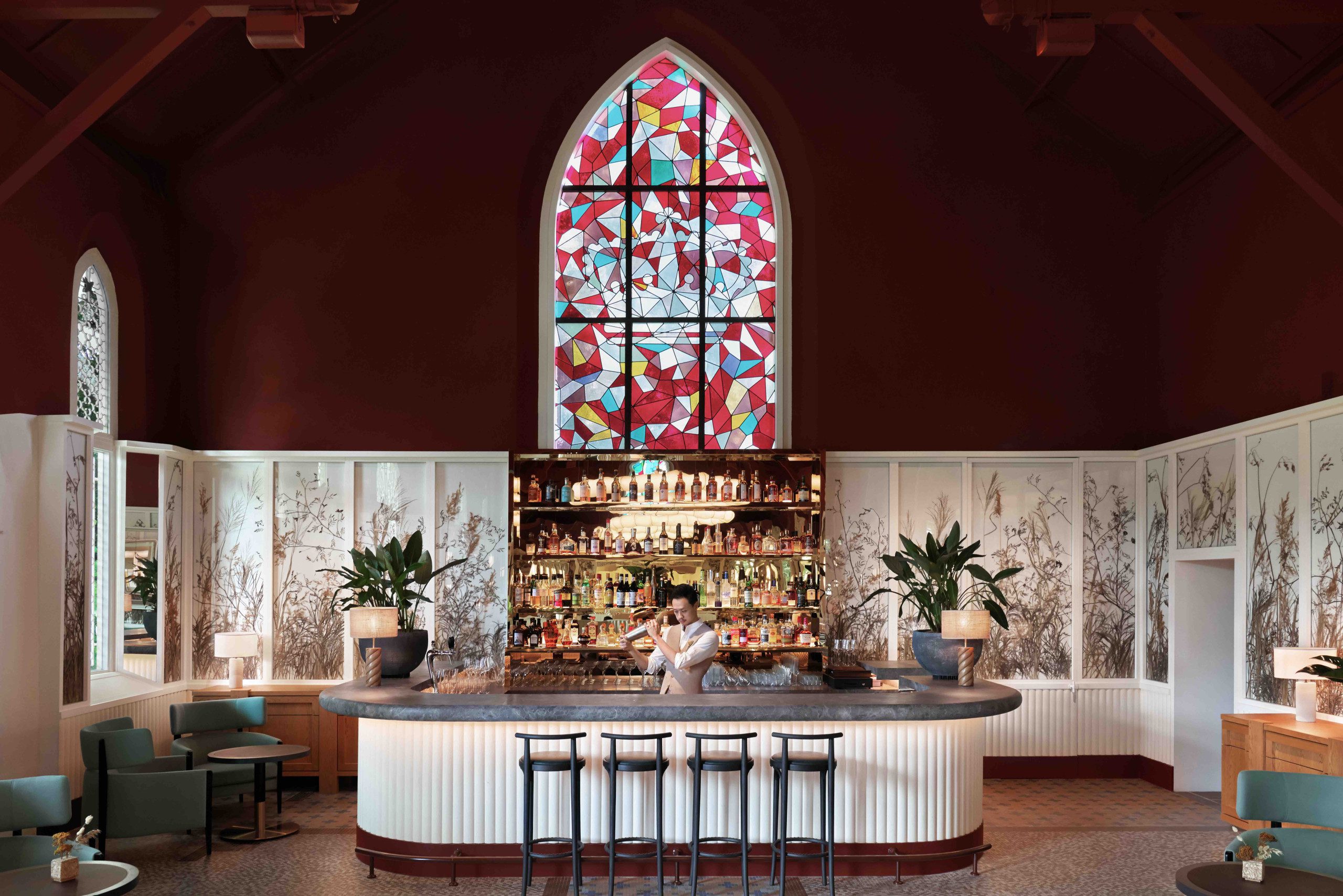 The bar in Claudine with a bartender mixing a drink in the middle behind the bar