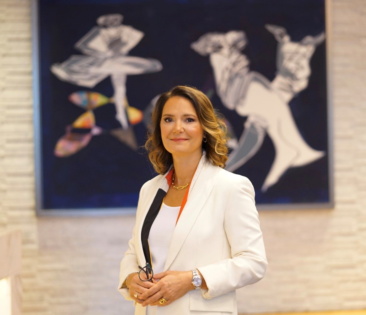 Photo of Deniz Met, the Director of Marketing at Raffles Istanbul with an art piece in the background