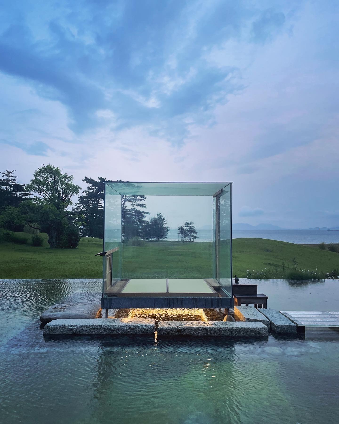 Glass Tea House Mondrian with trees in the background and water in the foreground