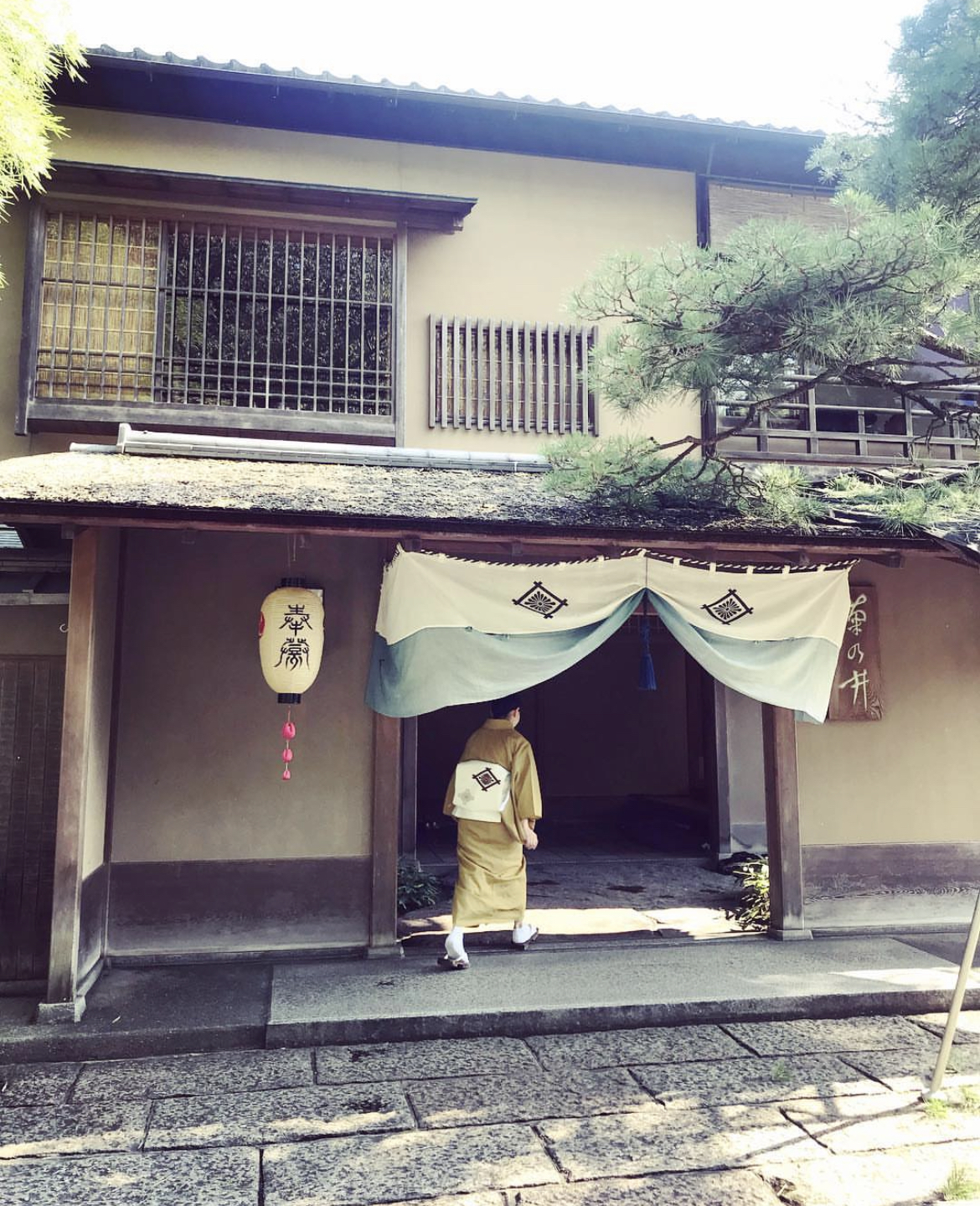 The exterior of Kikunoi with a lady walking in on a sunny day