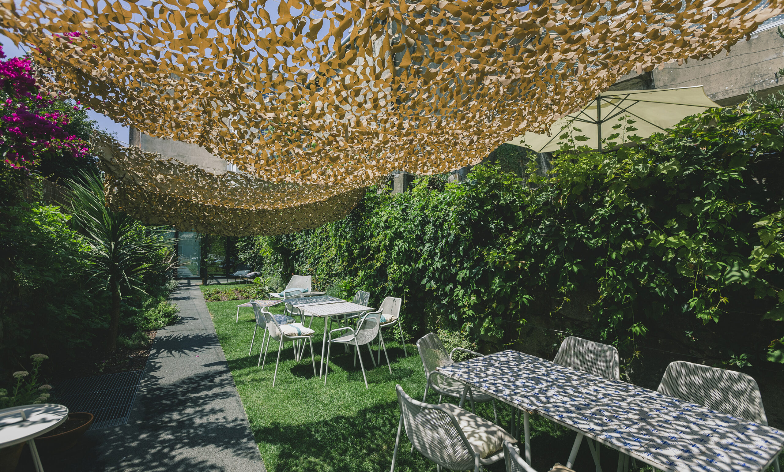 Tables in greenery in Rosa et Al, hotel and restaurant