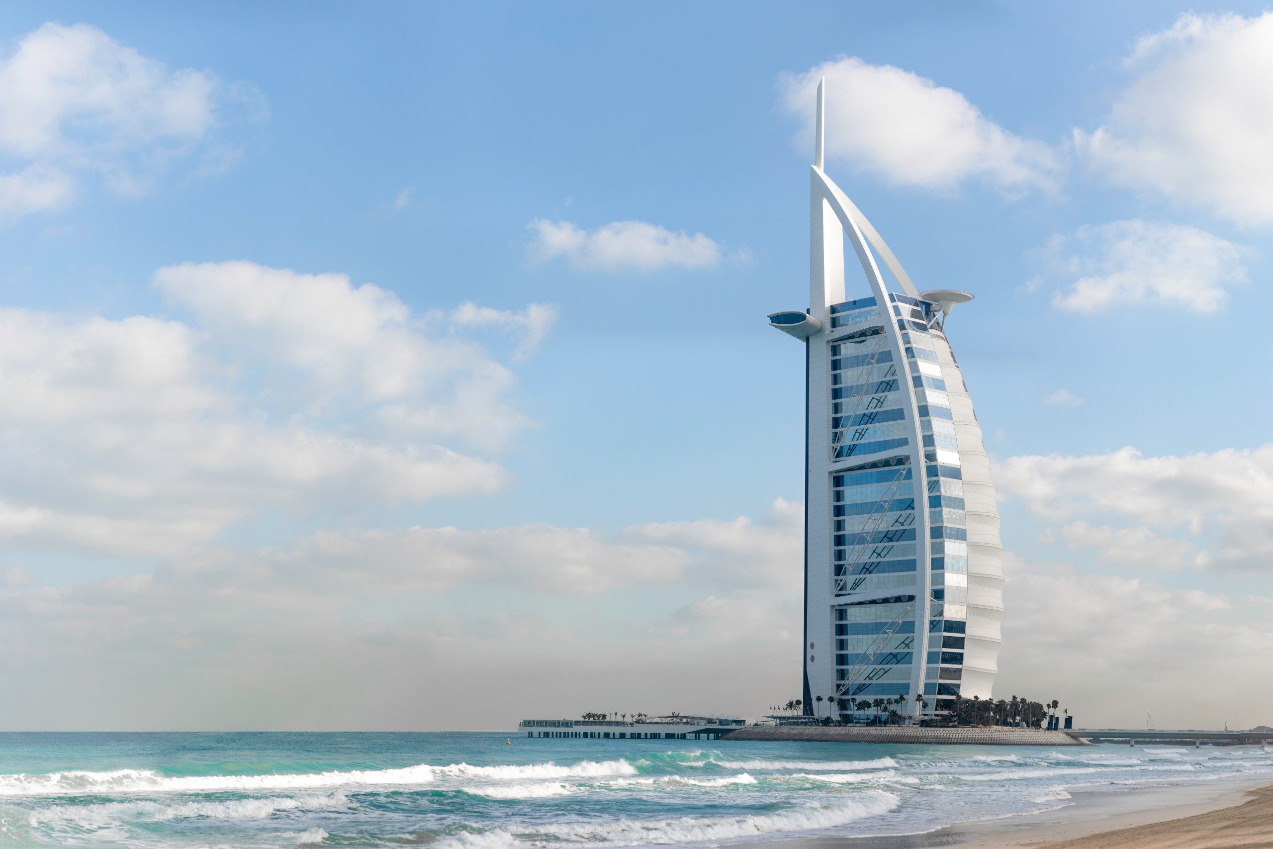 Jumeirah Burj Al Arab standing next to the beach on a sunny day