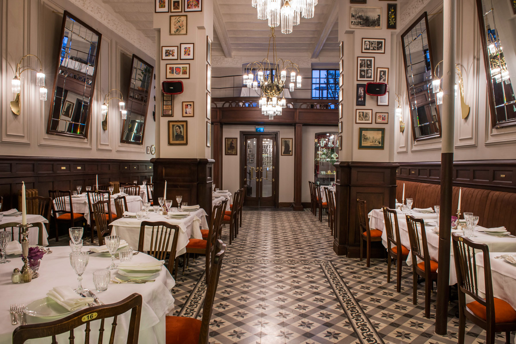 The inside of the restaurant, Rejans with tables, images and mirrors on the walls