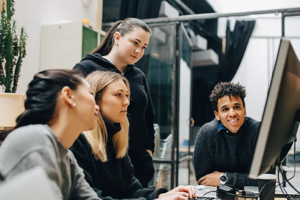 Young professionals engaging around a computer screen