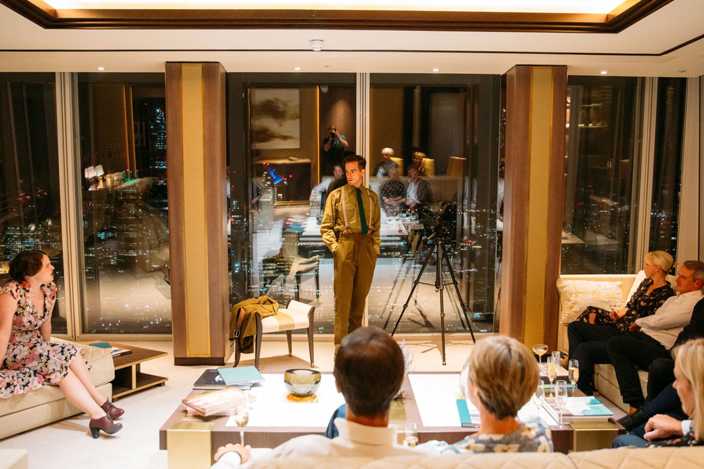 a man standing in a luxurious hotel room surrounded by glass windows