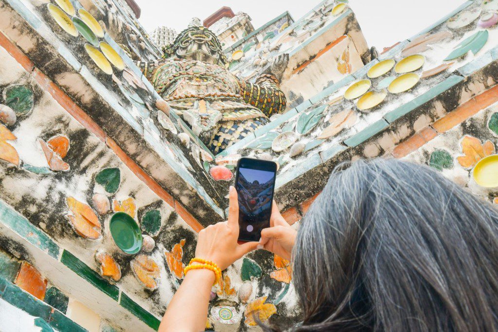 a person taking a picture of a buddhist temple