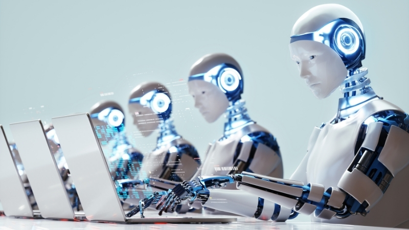 a group of robots sitting at a table typing on laptop computers