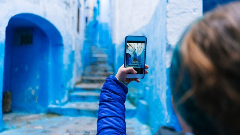 a faceless social media influencer taking a picture in chefchaouen, morocco, north africa