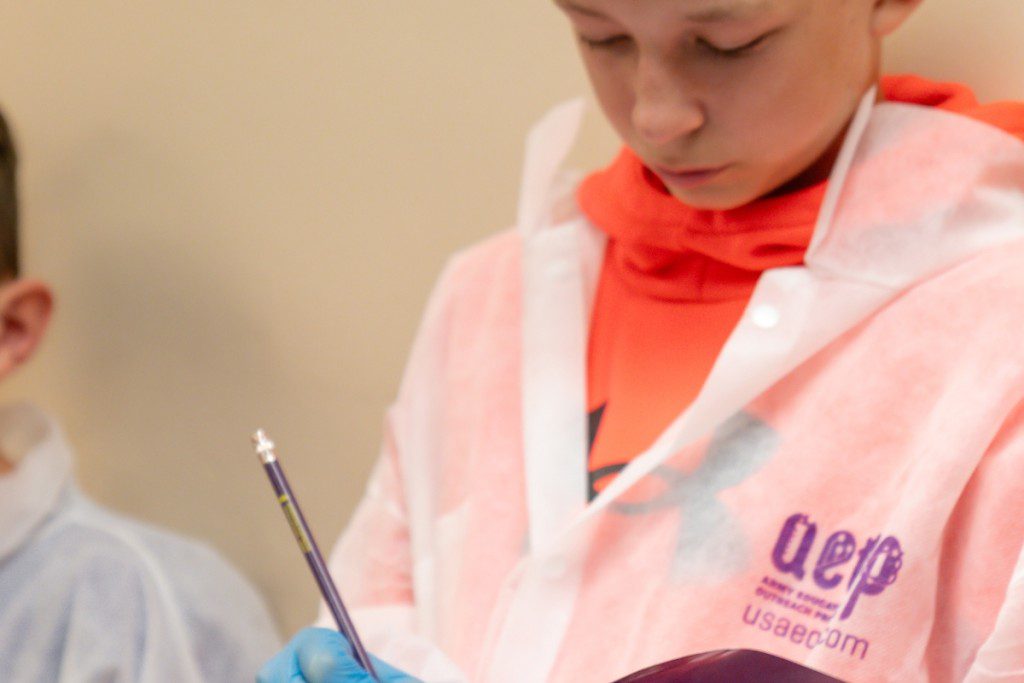 A person in a lab coat writing on a piece of paper