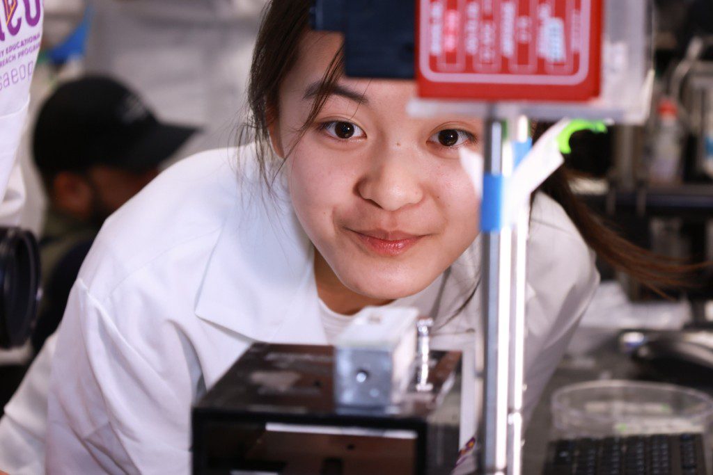 A person in a lab coat is looking at something
