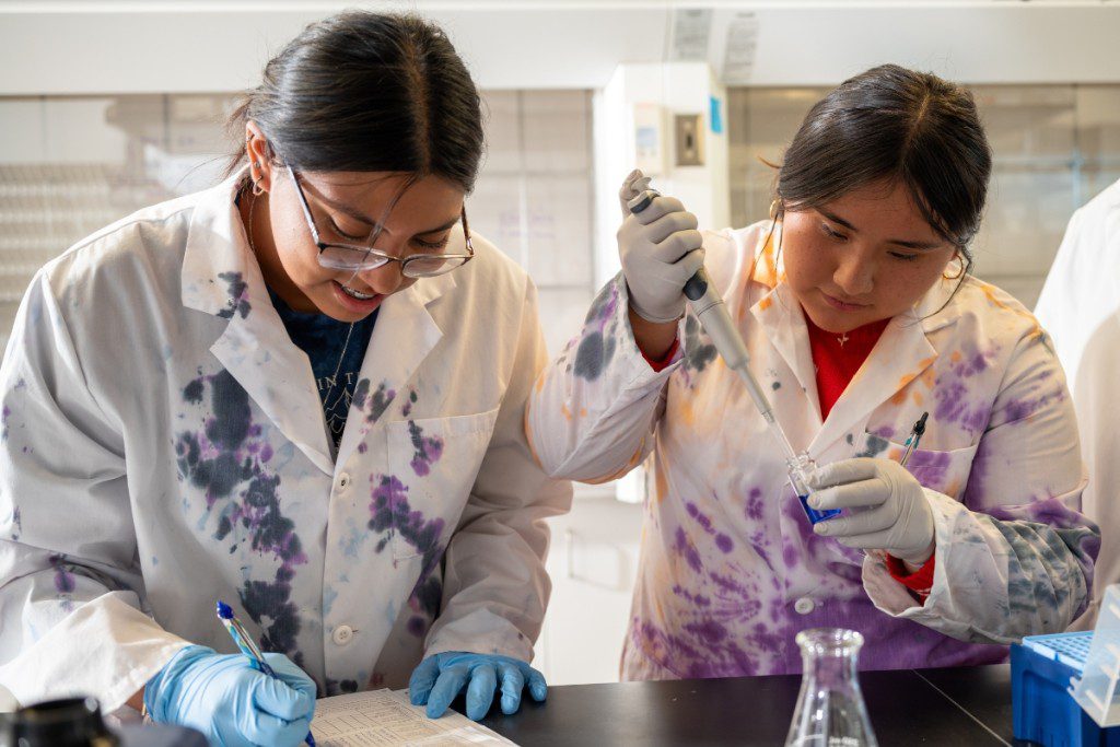 two people in lab coats working on a project