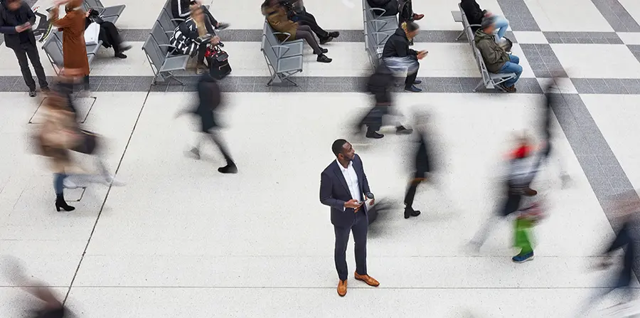 One man in focus among blurred people rushing