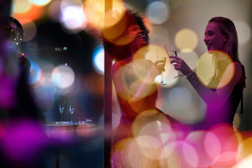 a group of people having a good time at a party with bokeh lights