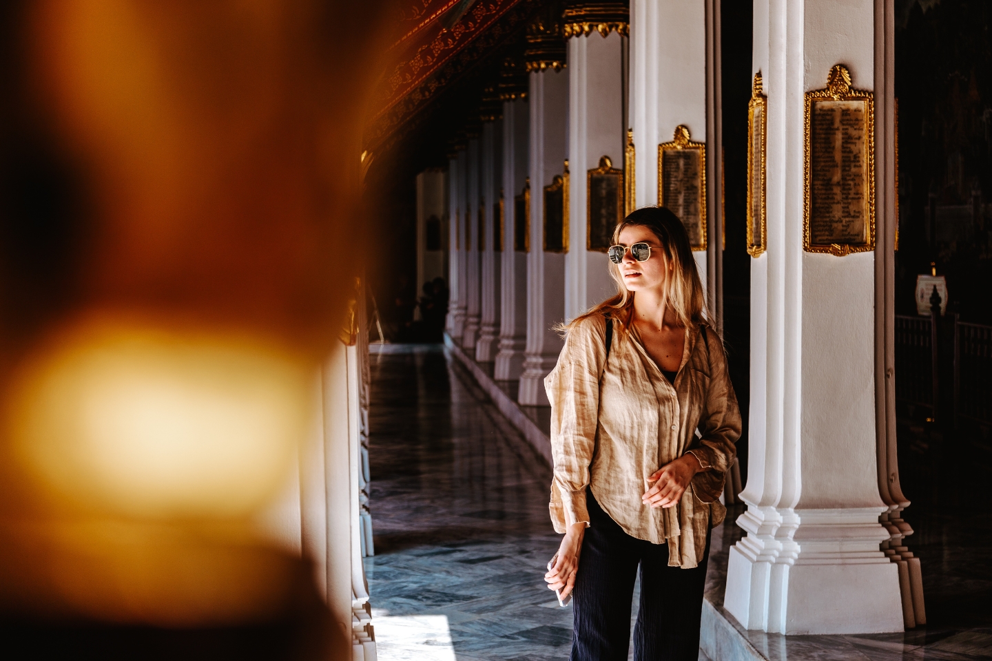 A person is standing in the middle of an ornate hallway
