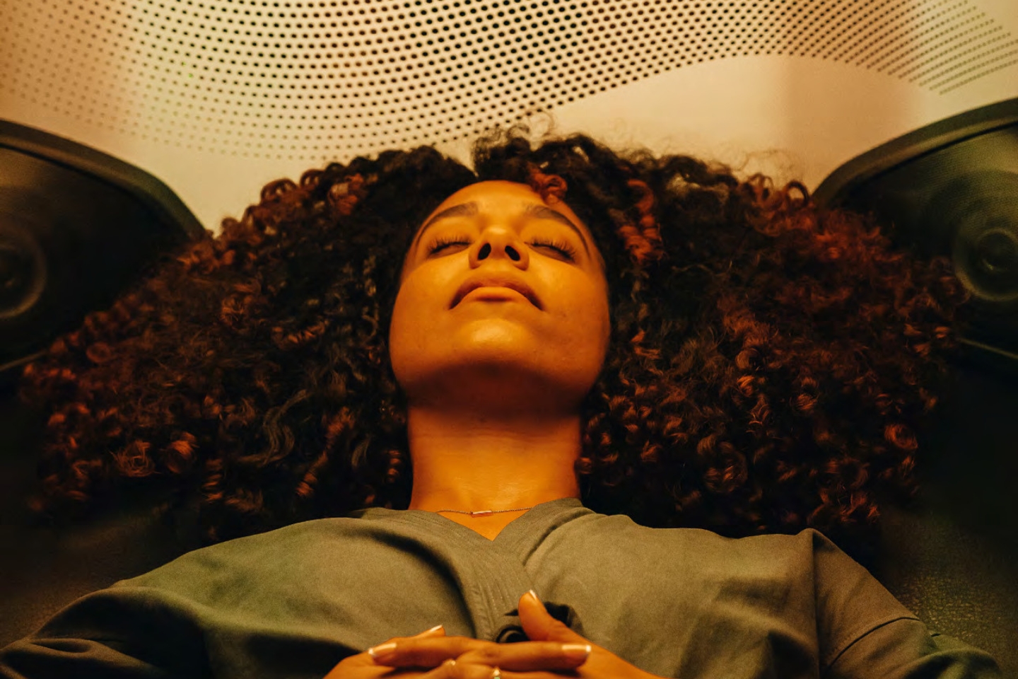 a person laying in a hi-tech spa chair with their eyes closed